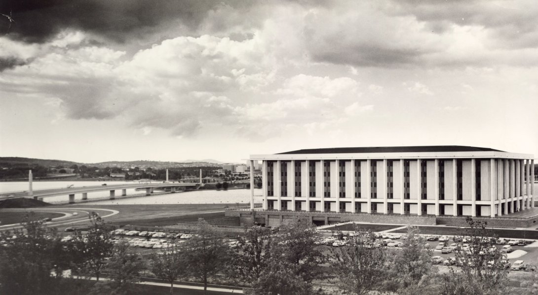 Black and white landscape of the National Library of Australia building and the landscape around including the bridge on the right side