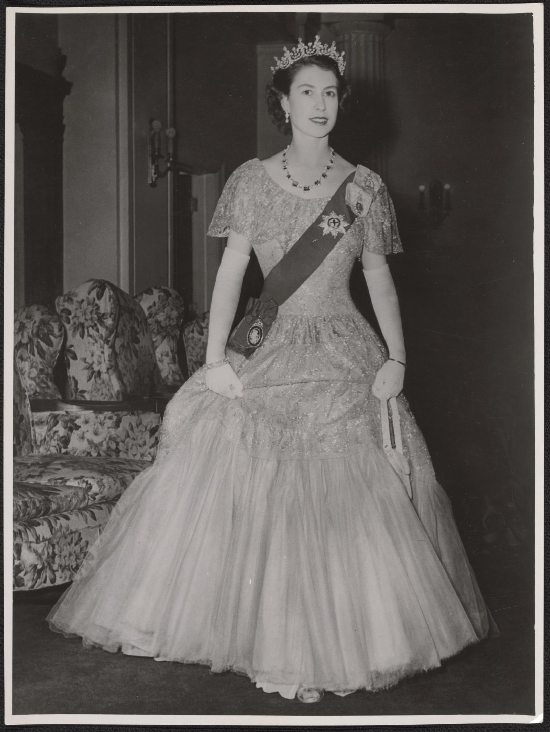 A black and white image of the Queen in 1954 dressed in full formal dinner attire.