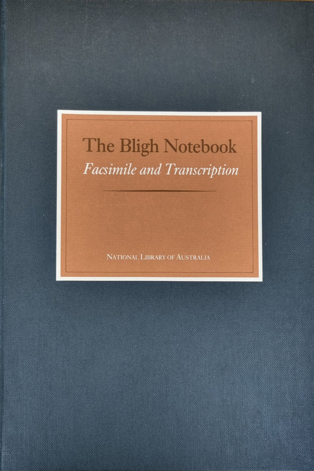 The Blight Notebook book cover. A navy background with a tan square in the centre with text 'The Blight Notebook Facimile and Transcription, National Library of Australia