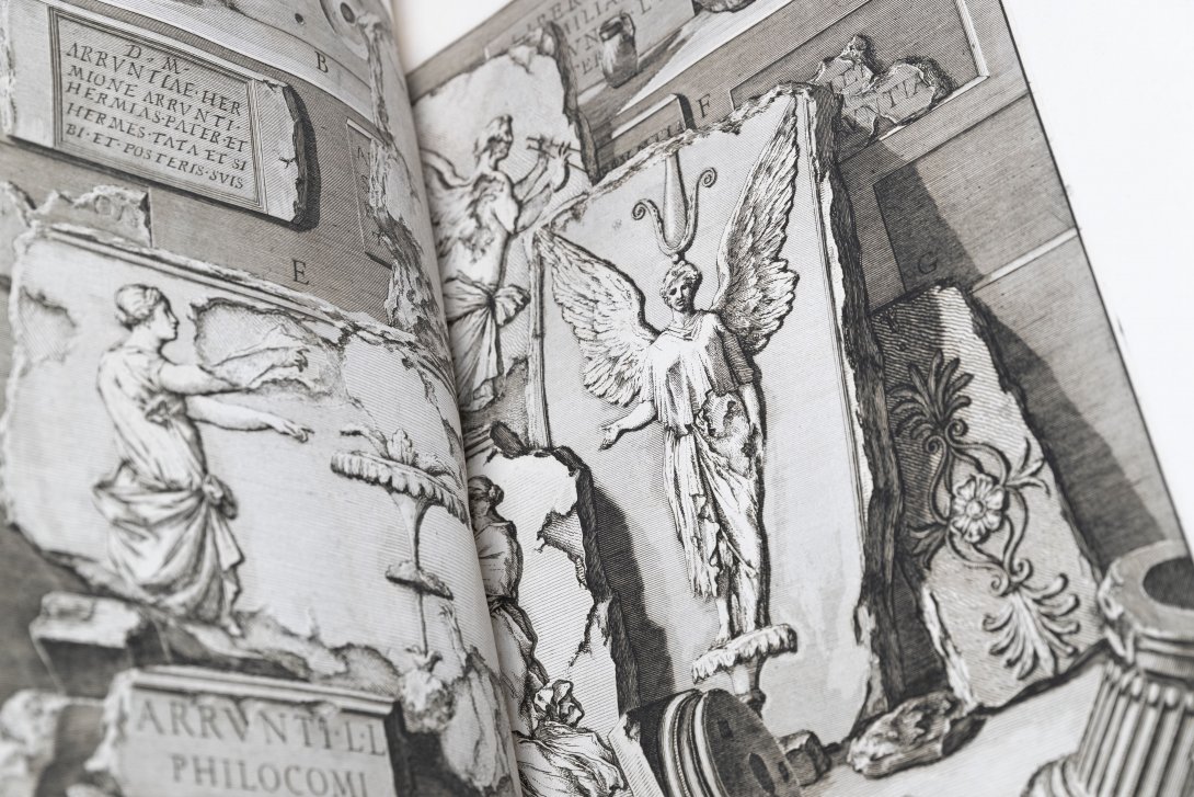 A close up of a black and white illustration of angels and a griffin in individual boarders. 