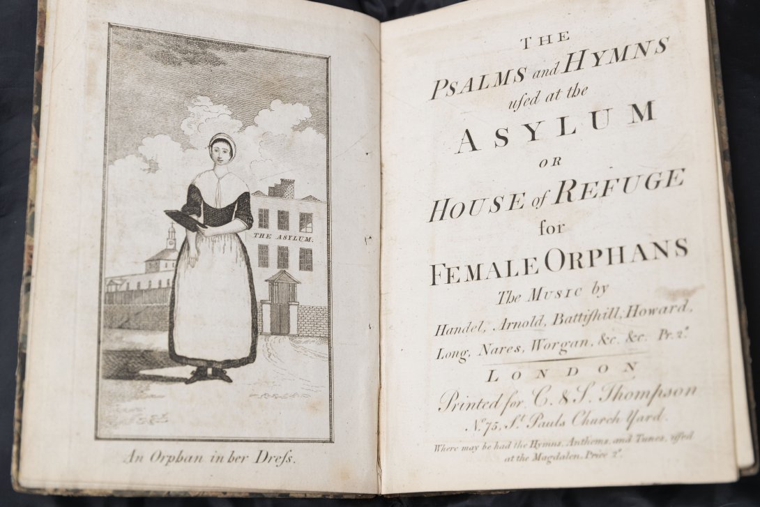 Old book with black and white illustration of a nun
