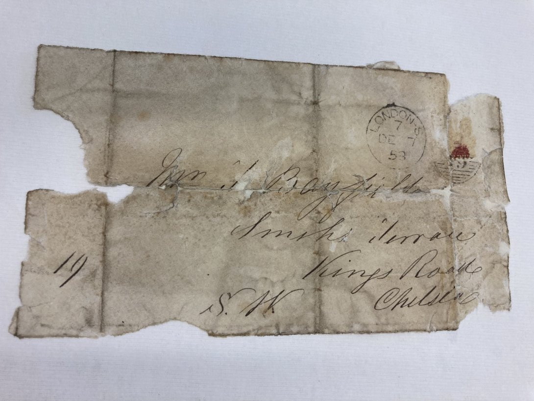 A worn letter with illegible writing and a stamp in the top right.