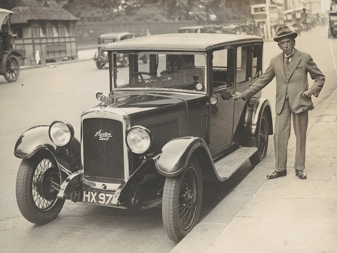 Billy Hughes standing next to a car