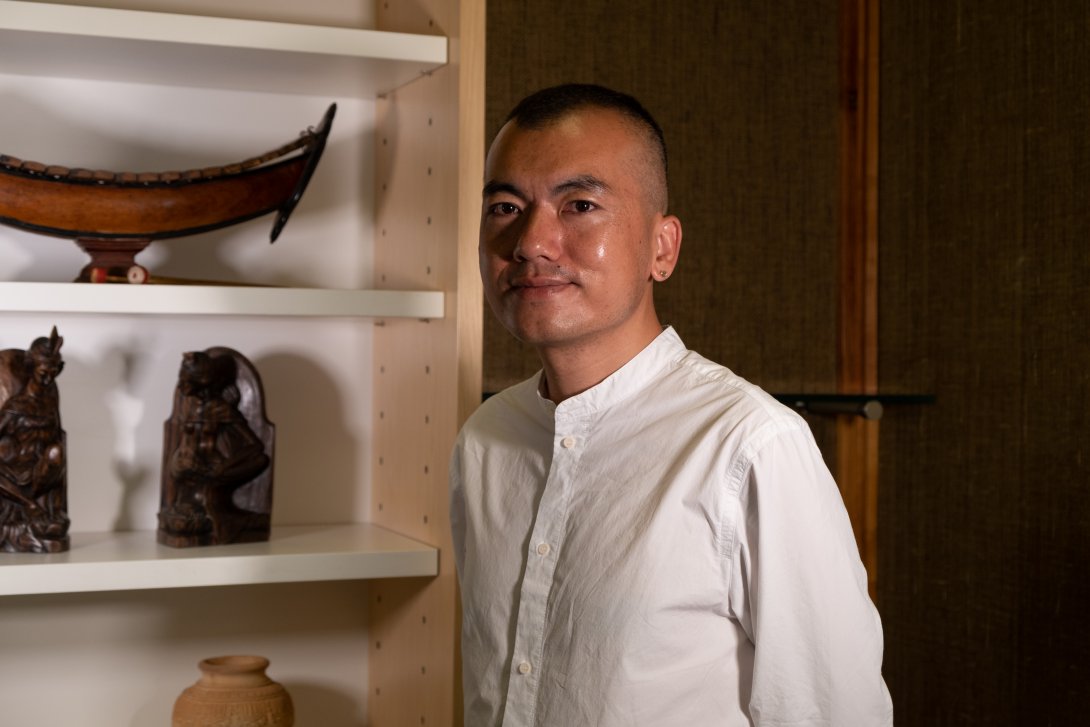 Man in white shirt smiling and standing in front of shelf display