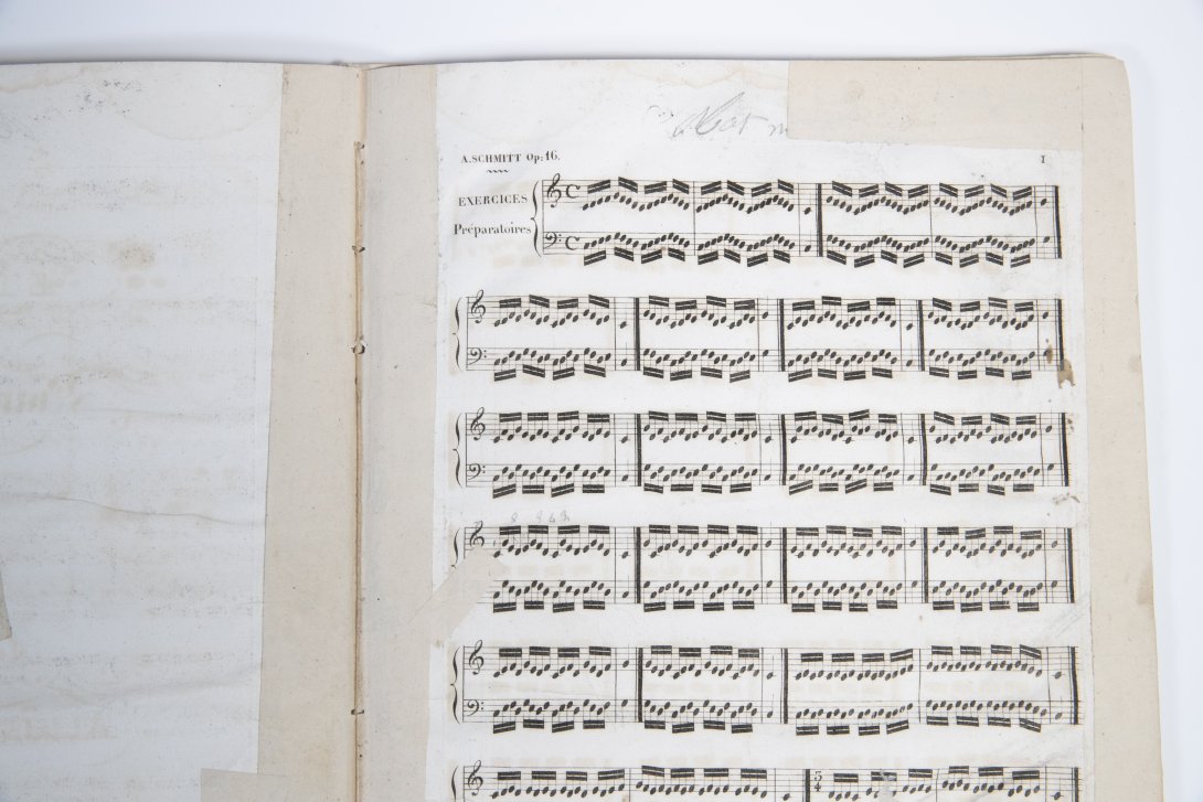 Partial view of early edition of Schmitt's exercises: tape appears on most edges of the paper.