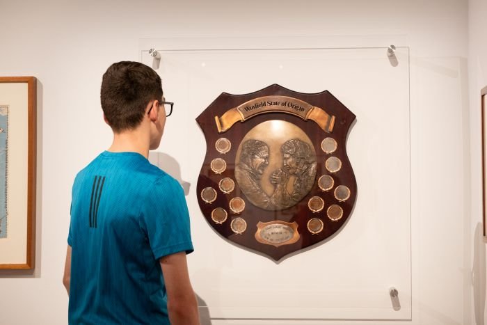 Boy looking at the Winfield State of Origin plaque