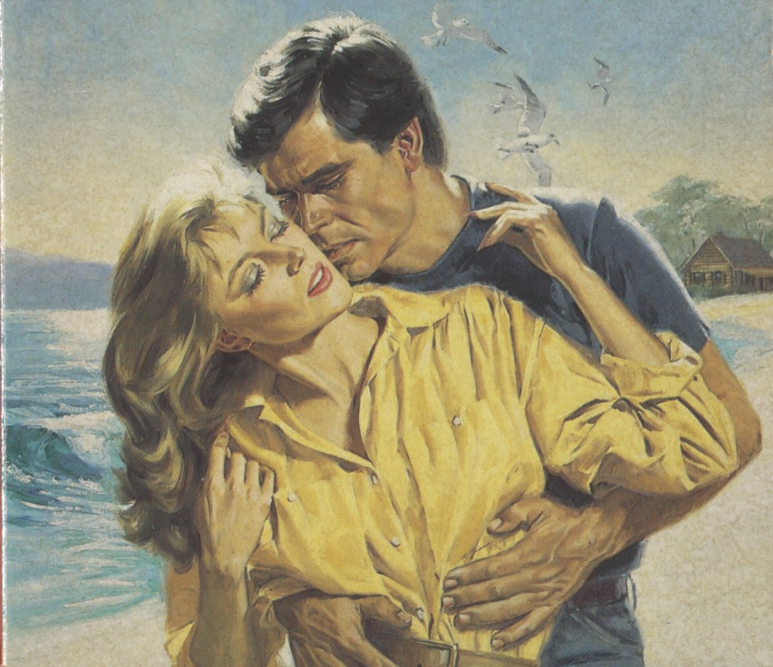 Blonde woman in a yellow shirt standing in front of a man with dark hair in a blue shirt with his hands on her waist on a beach