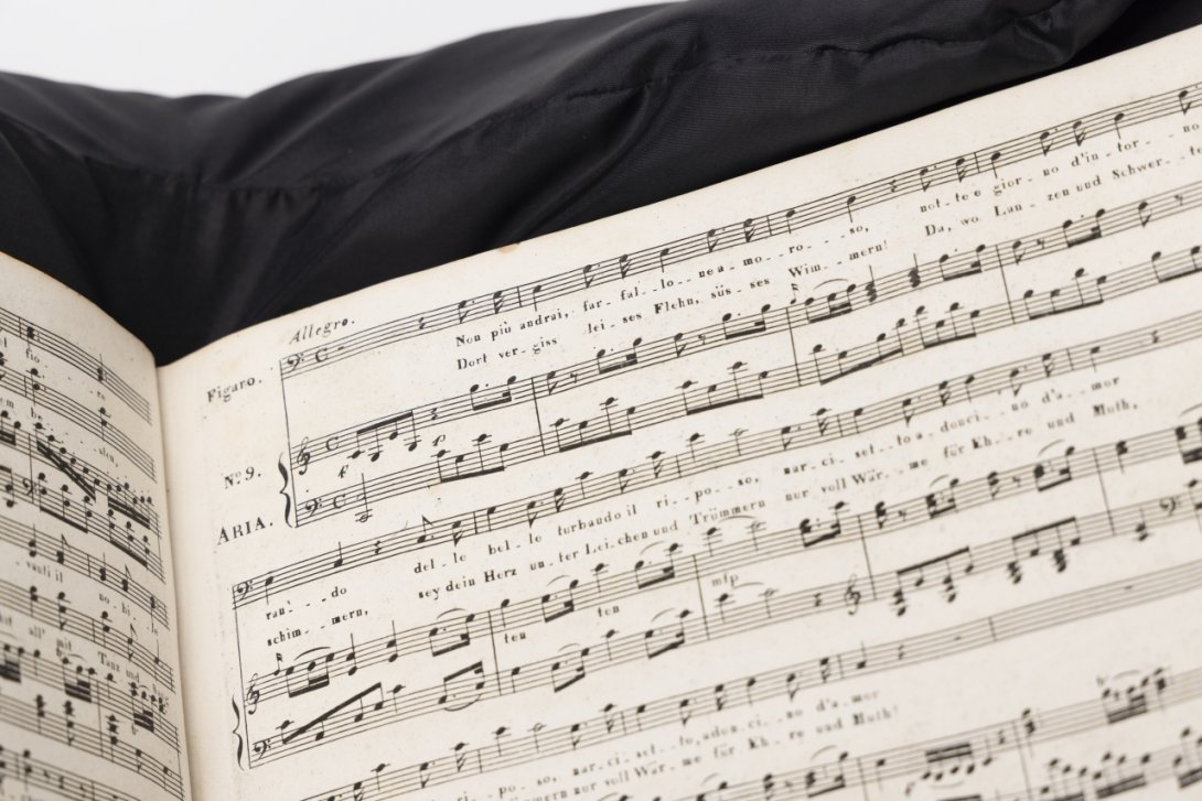 Printed music score (partial view) sitting on a black cushion
